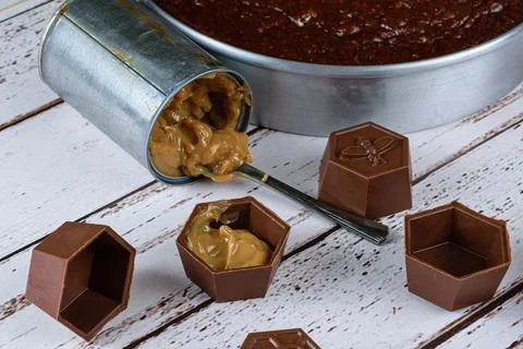 Small mold of chocolate filled with dulce de leche. In the background, roasti Stock Photos