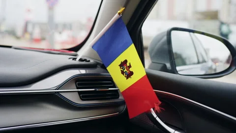 Small Moldovan national flag placed on car dashboard inside vehicle Stock Footage 331056079