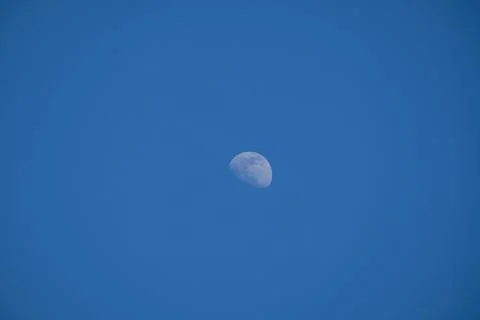 Small moon on a blue background - third quarter Stock Photos