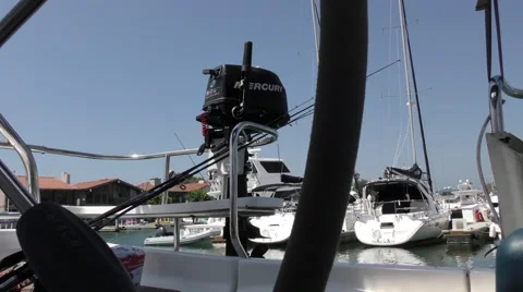 Small motor attached to stern of sail boat view aft from cockpit at dock with Stock Footage 67513351