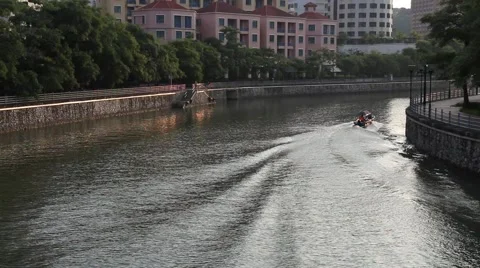 Small motorboat creates wake round bend in Singapore River 스톡 동영상 61474636