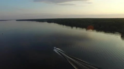 A small motorboat quickly glides over the surface of the river. Aerial view. 스톡 동영상 64817623