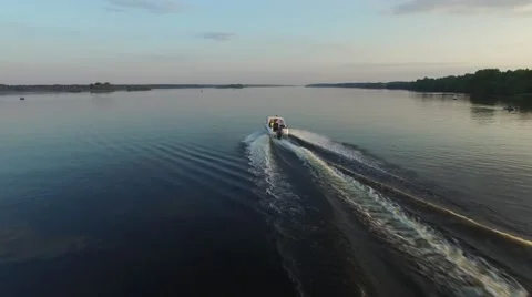 A small motorboat quickly glides over the surface of the river. Aerial view. Stock Footage 64817639
