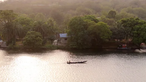 Small motorboat on Volta River at sunset Stock Footage 299751636