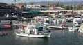 Small motorboats in Paphos harbor with cafe and shops on pier HD Footage
