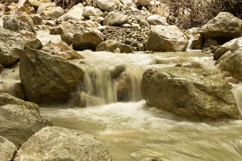 A small mountain cascade waterfall with muddy water after heavy rains. Stock-Fotos