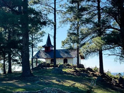Small mountain chapel surrounded by pine trees Stock Photos
