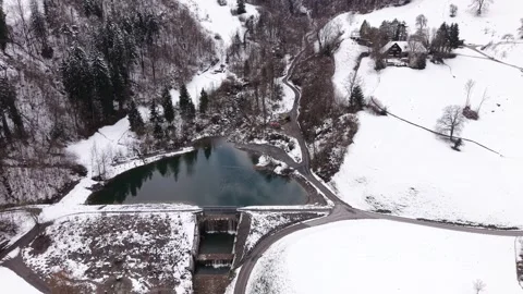 Small Mountain Dam With Narrow Road Leading Into Alps Static Aerial Tilt Shot Stock-Footage 331588677