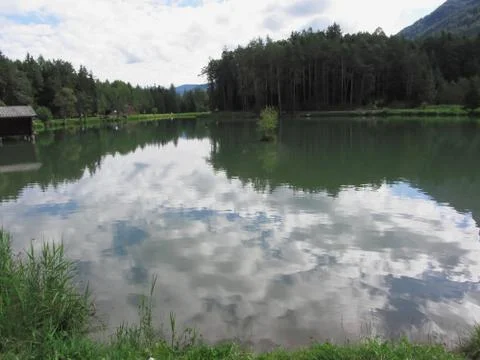 Small mountain lake with reflections of clouds. Fie allo sciliar, South Tyrol Stock Photos