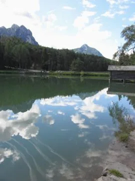 Small mountain lake with reflections of clouds. Fie allo sciliar, South Tyrol Stock Photos