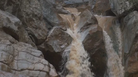 Small mountain river flowing over brown rocks Video stock 100269373