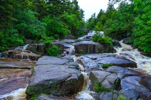 A small mountain river flows along a stone cascade of small waterfalls, Hik.. Stock Photos