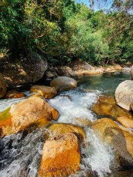 Small mountain river flows among large stones in mountainous areas through th Stock Photos