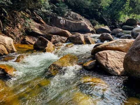 Small mountain river flows among large stones in mountainous areas through th Stock Photos