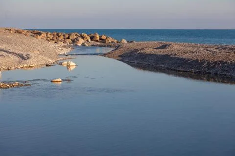 Small mountain river flows into the sea Stock Photos