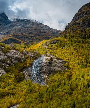 A small mountain stream flowing down a rock in a picturesque place near the Stock Photos