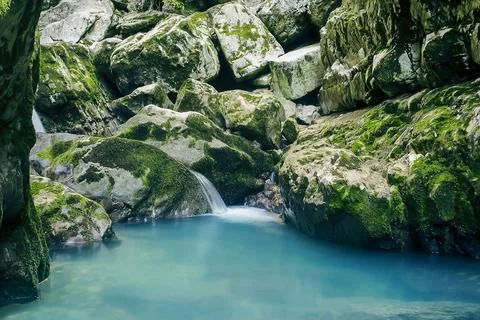 Small mountain stream, waterfall and small lake against the background of sto Stock Photos