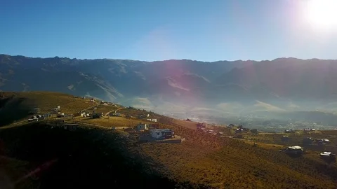 Small mountain village, mist, sun flares and sunset, aerial shot Stock Footage 88567082