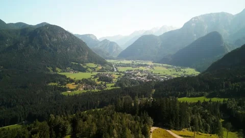 Small mountain village in a valley surrounded by forests and mountains Stock Footage 250084334