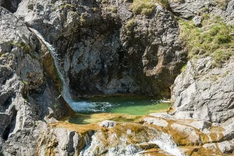Small Mountain Waterfall and Emerald Rock Pool Among Limestone Cliffs on a .. Stock Photos