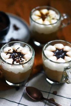 Small mugs with a three-layer coffee-caramel dessert. Delicious pudding in gl Stock Photos