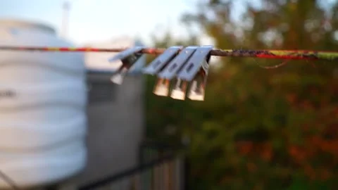 Small multi cloth pegs on the rope. Cloth pins swinging on the air without cl Stock Footage 148204146