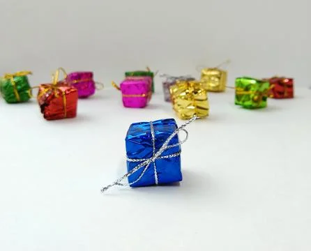 Small multi-colored boxes with gifts are scattered on a white background Stock Photos