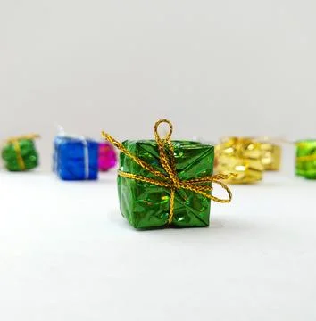 Small multi-colored boxes with gifts are scattered on a white background Stock Photos