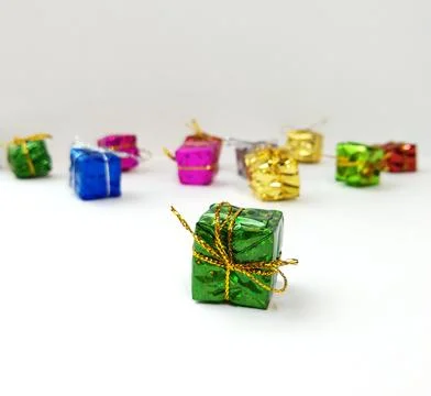 Small multi-colored boxes with gifts are scattered on a white background Stock Photos