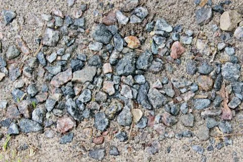 Small multi-colored crushed stone located on damp earth Stock Photos