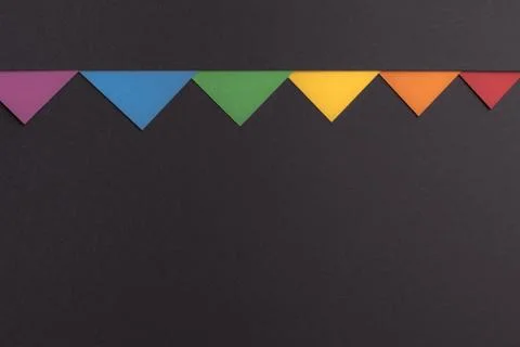 Small multicolor triangles on a minimalistic black background, copy space. Stock Photos