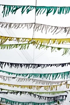 Small multicolored flags are attached to the thread and hang against Stock Photos
