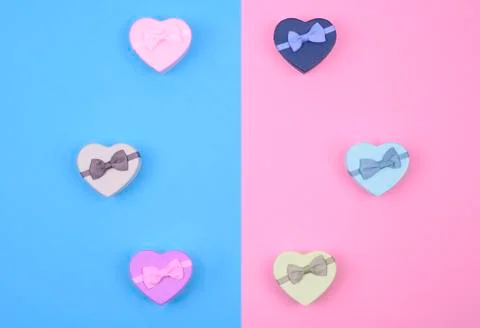 Small multicolored gift boxes hearts on blue and pink background, top view, copy Stock Photos