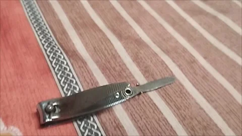 Small nail clippers are placed on the mattress Stock Footage 293056944