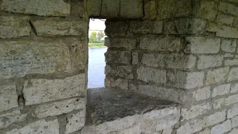 Small narrow window in the old ancient stone wall of Kremlin Pskov, Russia. View Stock Photos