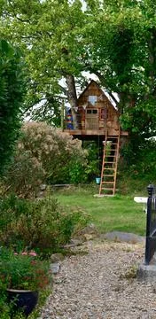 A small neat triangular treehouse in a garden Stock Photos