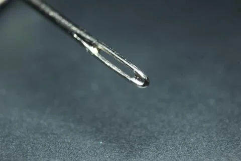 Small needle with empty eyelet, isolated over the black background. Stock Photos