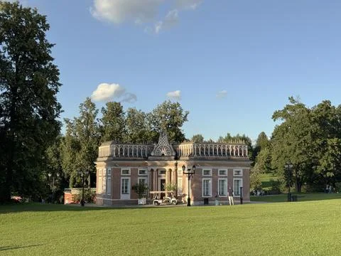 Small neoclassical building in park setting under clear sky suitable for ba.. Stock Photos