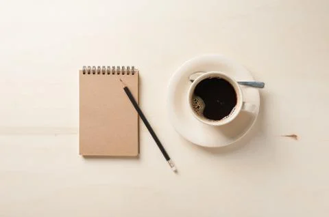 Small notebook and coffee cup Stock Photos