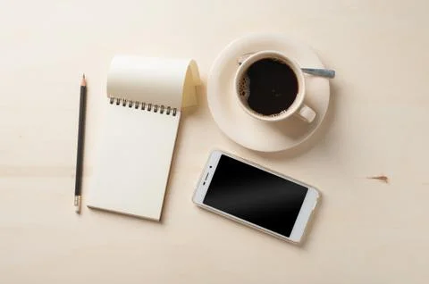 Small notebook and coffee cup Stock Photos