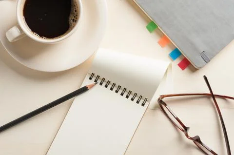 Small notebook and coffee cup Stock Photos