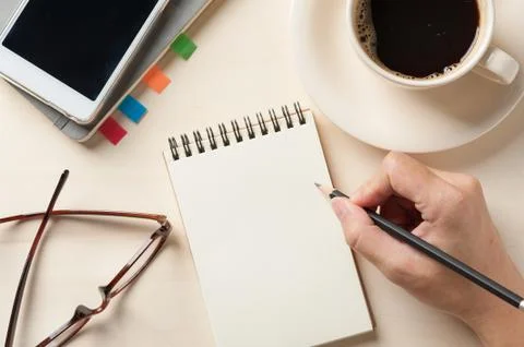 Small notebook and coffee cup Stock Photos