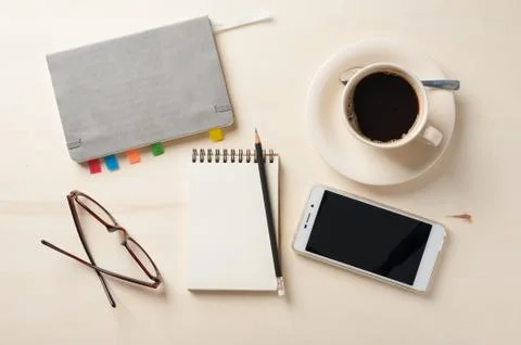 Small notebook and coffee cup Stock Photos