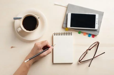 Small notebook and coffee cup Stock Photos