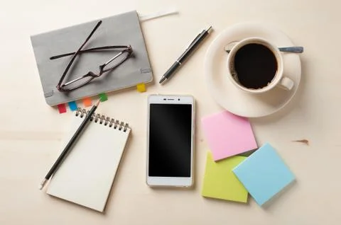 Small notebook and coffee cup Stock Photos