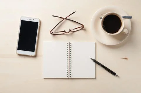 Small notebook and coffee cup Stock Photos