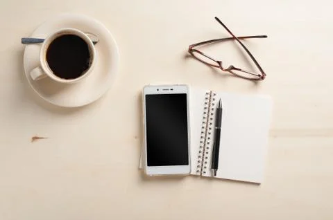 Small notebook and coffee cup Stock Photos