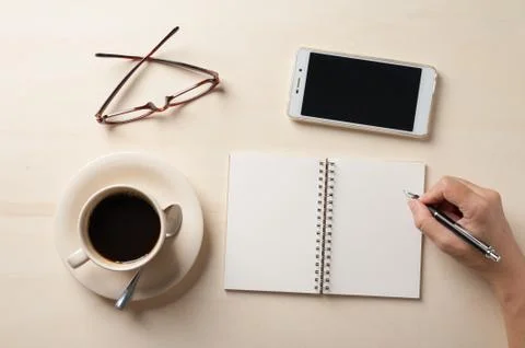 Small notebook and coffee cup Stock Photos