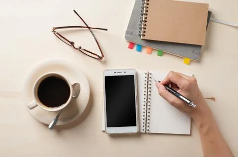 Small notebook and coffee cup Stock Photos