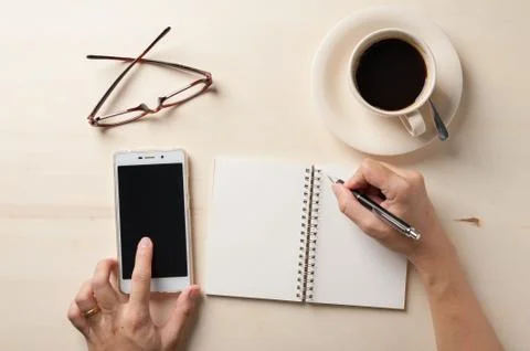 Small notebook and coffee cup Stock Photos